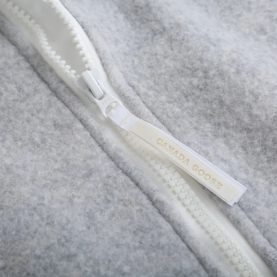 P770 Canada Goose Fleece Badge Hooded Jacket Fabric selection: Wool fleece fabric blended with wool as the main body and a very small amount of spandex and polyester fibers. Wool is a core natural ingredient that provides unparalleled temperature regulation, antibacterial and anti-odor properties and a skin-friendly feel. The feeding of a small amount of spandex gives the fabric a certain degree of four-way elasticity, making it non-restrictive during daily activities. As the basis of fleece's structure, polyester fiber enhances the fabric's durability, wrinkle resistance and quick-drying properties. It contributes to the loft of the fleece and provides functions such as trapping air.  Detail 1: The sleeves and hem are closed with 2×2 ribbing. Its strong elasticity can closely fit wrists and waists of different thicknesses, forming an effective 'seal' to prevent cold wind from blowing back. It can still maintain its original shape after repeated stretching and use, and is not easy to loose and deform. And the ribbed cuffs can convey a sense of design and enhance the visual beauty.  Detail 2: The combination of hood design and elastic buckle improves warmth and windproof performance when wearing.  Accessories: 1:1 customized elastic drawstring buckle, 1:1 customized zipper pendant, 1:1 customized armband SIZE: S M L XL hot new color